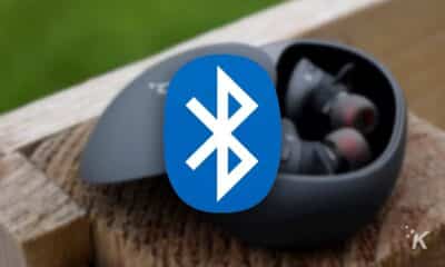 bluetooth logo with blurred earbuds in the background