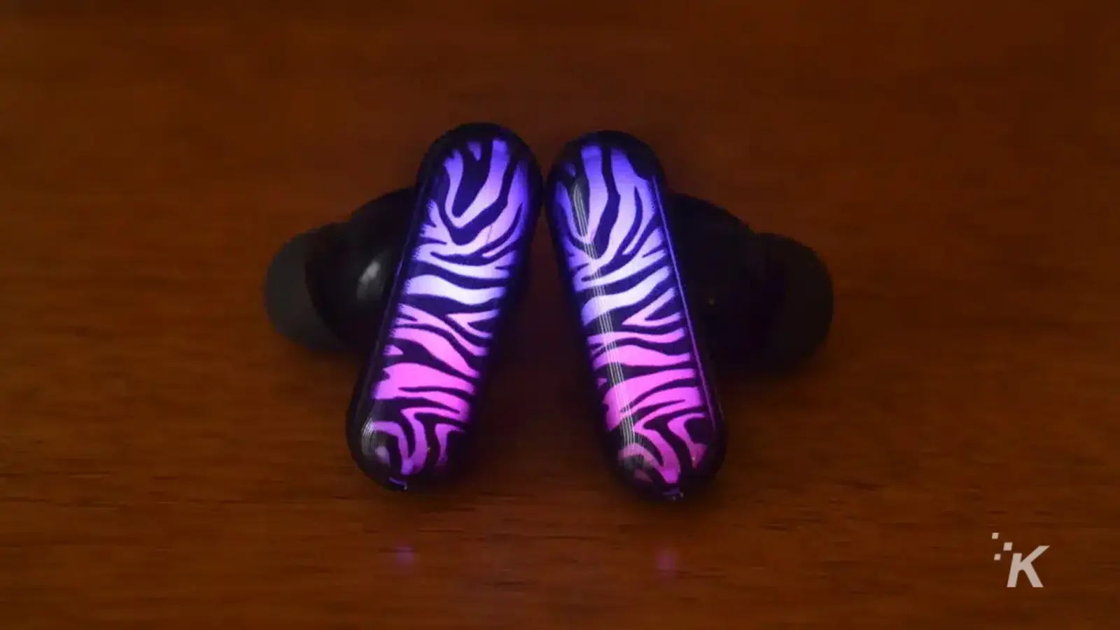 GPods earbuds purple zebra led on wooden table